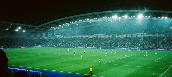 Football match in a packed stadium under the floodlights